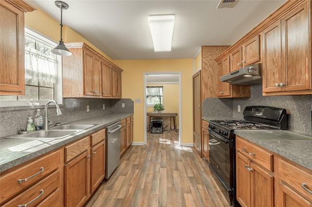 kitchen featuring black gas range oven, visible vents, a sink, under cabinet range hood, and stainless steel dishwasher