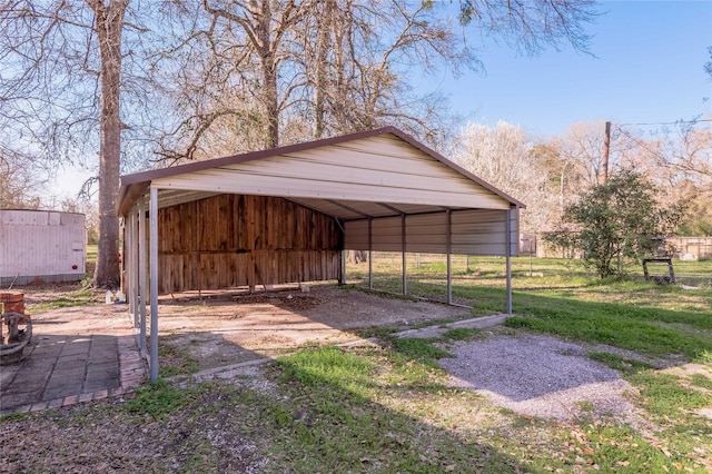 view of outdoor structure with a detached carport and driveway