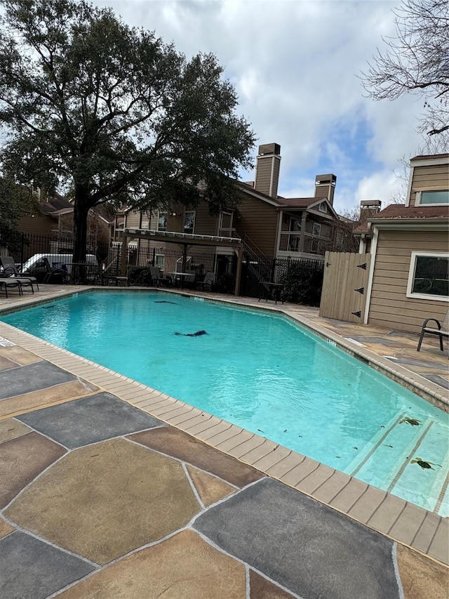 view of swimming pool featuring a fenced in pool, a patio, and fence