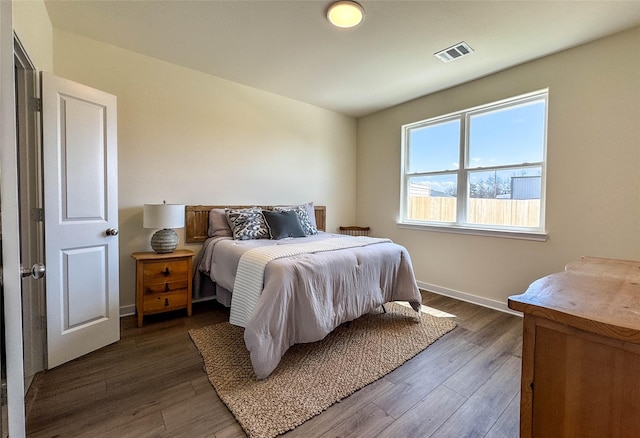 bedroom with dark wood finished floors, baseboards, and visible vents