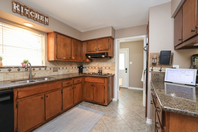 kitchen with brown cabinets, a sink, under cabinet range hood, tasteful backsplash, and dishwasher