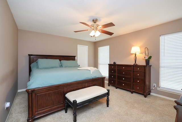 bedroom with light colored carpet, baseboards, and ceiling fan