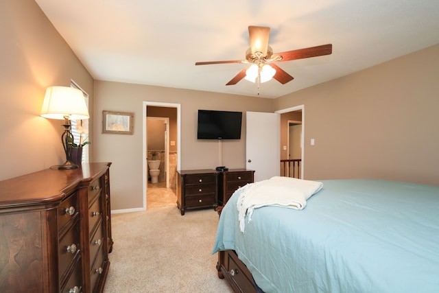 bedroom featuring light carpet, ensuite bathroom, and ceiling fan