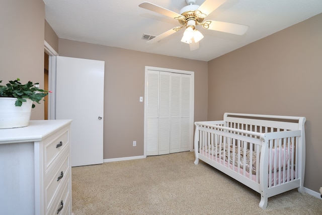 bedroom with visible vents, baseboards, light colored carpet, and a closet