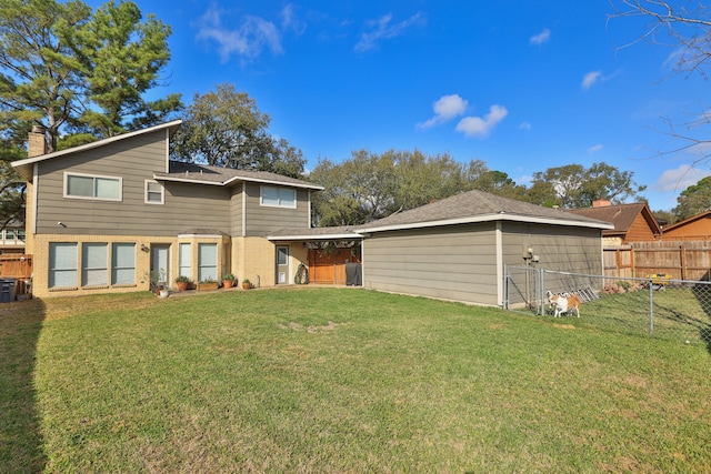 rear view of property featuring an outbuilding, a lawn, fence, and a chimney