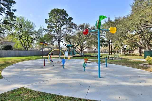 view of property's community featuring fence, playground community, and a lawn