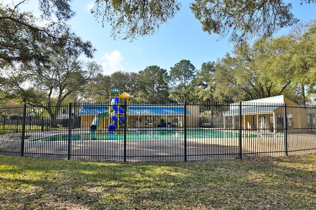 community pool featuring playground community and fence