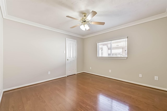 spare room featuring baseboards, a ceiling fan, wood finished floors, and crown molding