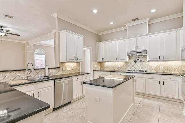 kitchen featuring under cabinet range hood, stainless steel appliances, dark countertops, and light tile patterned floors