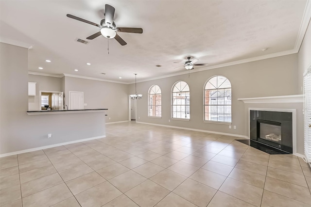 unfurnished living room with visible vents, ceiling fan with notable chandelier, baseboards, and ornamental molding