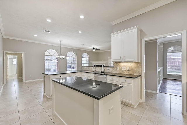 kitchen with light tile patterned floors, visible vents, a peninsula, dishwasher, and crown molding