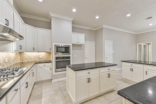 kitchen featuring visible vents, light tile patterned flooring, ornamental molding, stainless steel appliances, and under cabinet range hood