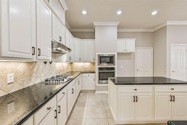 kitchen featuring under cabinet range hood, light tile patterned floors, stainless steel appliances, and crown molding