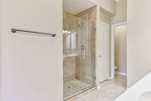 bathroom with tile patterned floors, a shower stall, toilet, and vanity