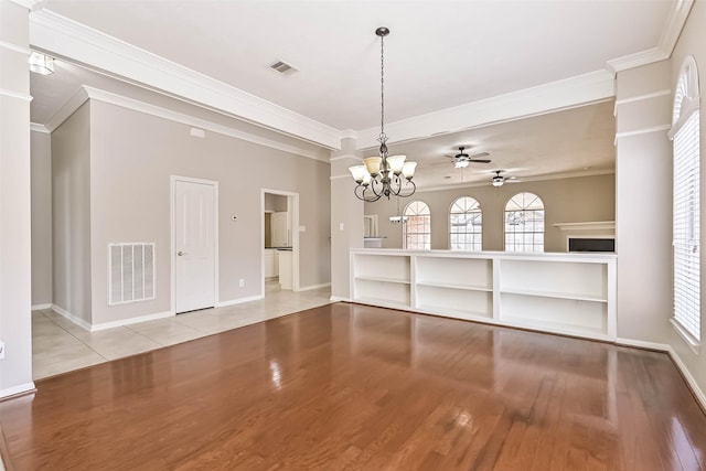 unfurnished dining area with visible vents, light wood-style flooring, ceiling fan with notable chandelier, and crown molding