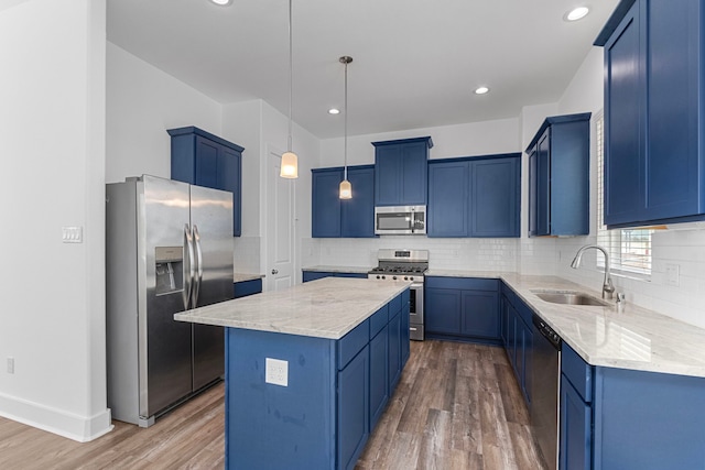 kitchen featuring blue cabinets, a sink, tasteful backsplash, a center island, and stainless steel appliances