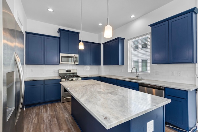 kitchen featuring dark wood finished floors, blue cabinetry, a sink, stainless steel appliances, and a center island