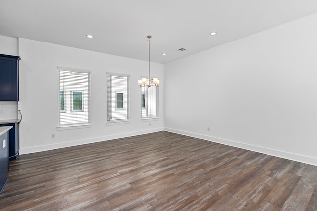 unfurnished living room featuring recessed lighting, a chandelier, and dark wood finished floors