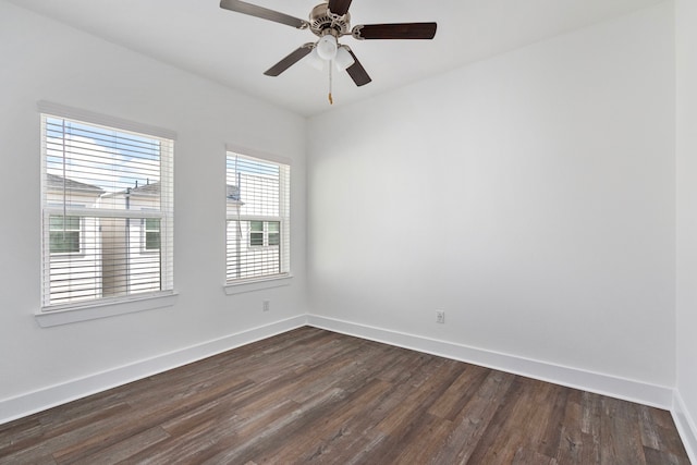 empty room with baseboards, ceiling fan, and dark wood-style flooring