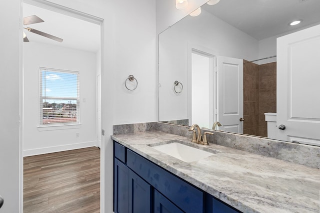 bathroom featuring ceiling fan, baseboards, recessed lighting, wood finished floors, and vanity