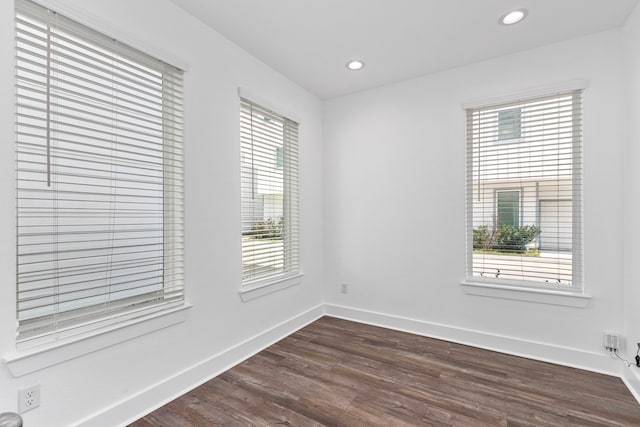 spare room featuring a wealth of natural light, baseboards, dark wood finished floors, and recessed lighting