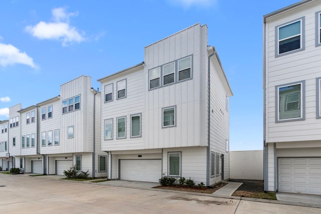 multi unit property featuring a garage, board and batten siding, and driveway