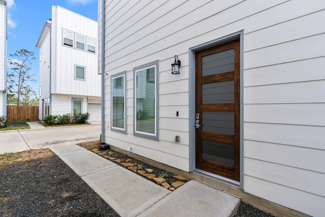 entrance to property with board and batten siding and fence