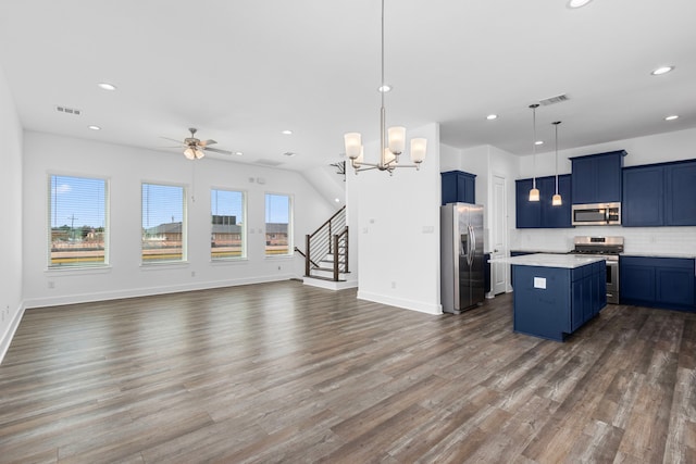 kitchen with blue cabinetry, dark wood-type flooring, appliances with stainless steel finishes, and open floor plan