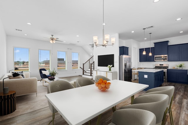 dining area with dark wood finished floors, visible vents, and stairs