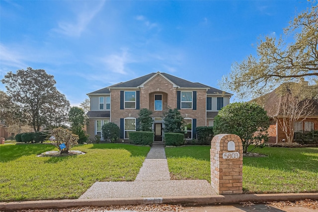 view of front of property featuring a front lawn and brick siding