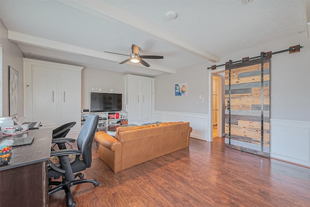 office area with wainscoting, a textured ceiling, ceiling fan, and wood finished floors