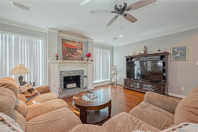 living area with a wealth of natural light, visible vents, and crown molding