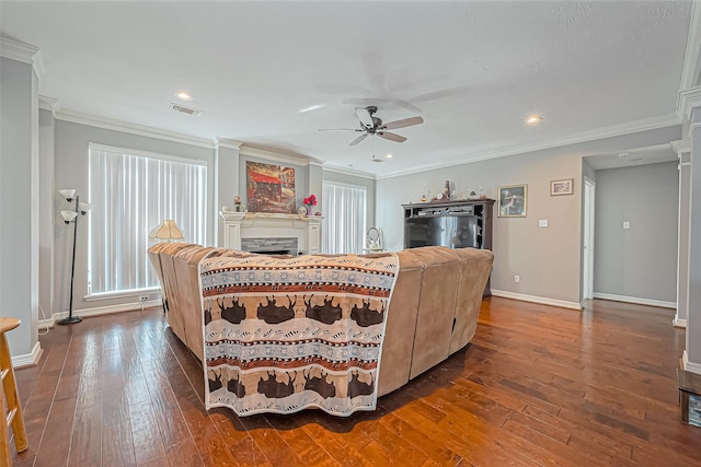 living area with crown molding, a ceiling fan, and dark wood-style flooring