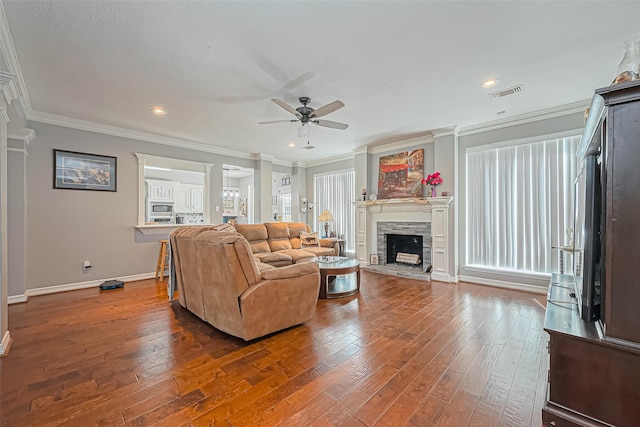 living area featuring visible vents, crown molding, a ceiling fan, and wood-type flooring