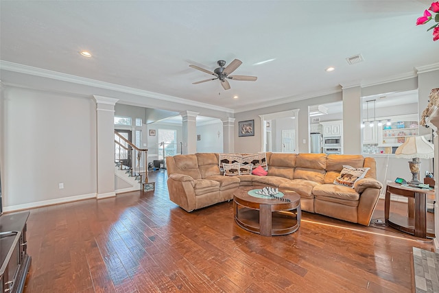 living area with visible vents, decorative columns, ornamental molding, ceiling fan, and wood-type flooring