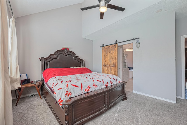 bedroom featuring a barn door, carpet floors, connected bathroom, baseboards, and ceiling fan