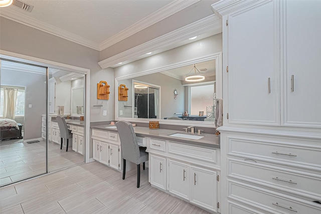 ensuite bathroom with visible vents, wood tiled floor, ornamental molding, ensuite bathroom, and vanity