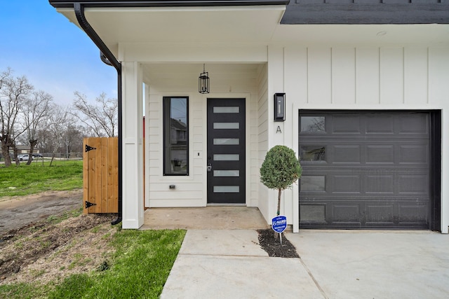 view of exterior entry featuring a garage, board and batten siding, and concrete driveway