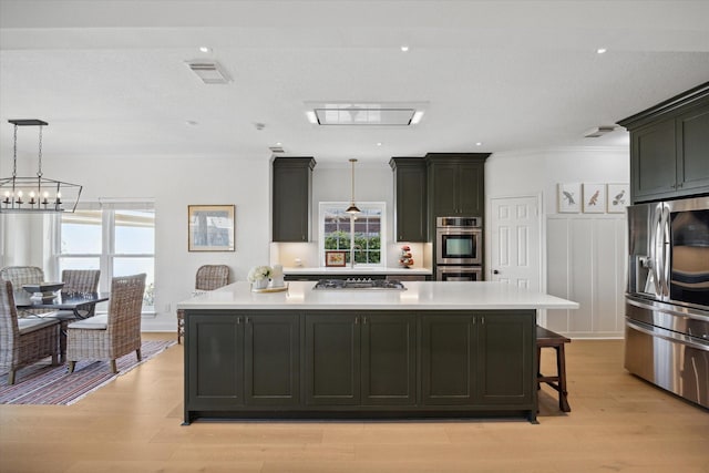 kitchen with visible vents, a large island, appliances with stainless steel finishes, and light countertops