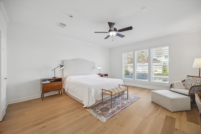 bedroom featuring visible vents, baseboards, ceiling fan, ornamental molding, and light wood-type flooring