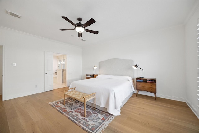 bedroom with visible vents, baseboards, light wood-style flooring, and ornamental molding