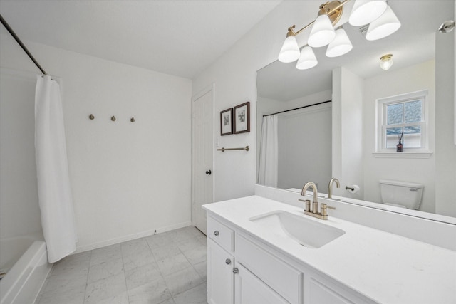 bathroom with toilet, vanity, and baseboards