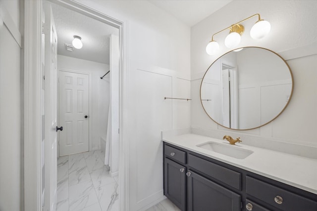 full bath with visible vents, curtained shower, vanity, marble finish floor, and a textured ceiling