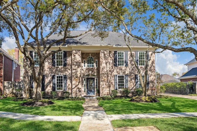 view of front facade with a front yard, a gate, and fence