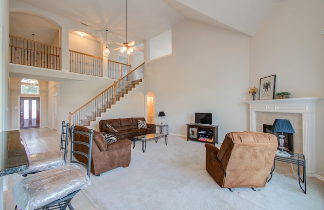 living room featuring a fireplace, stairway, carpet, and baseboards