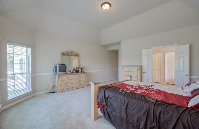 bedroom with vaulted ceiling, light colored carpet, and baseboards