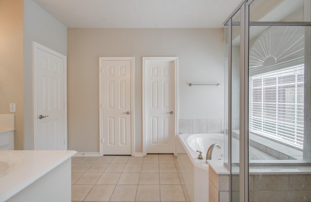 full bathroom with tile patterned flooring, baseboards, a stall shower, a bath, and vanity