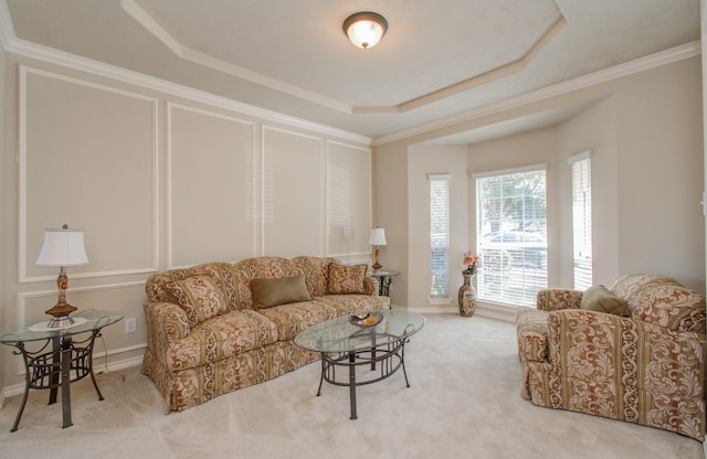 carpeted living room with a tray ceiling, baseboards, and ornamental molding