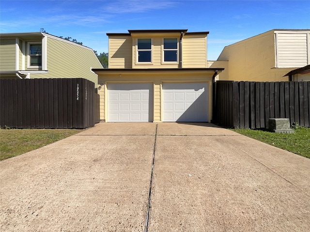 garage with driveway and fence