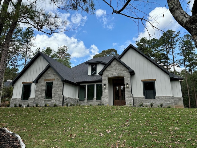 modern farmhouse with stone siding, board and batten siding, a front lawn, and a shingled roof